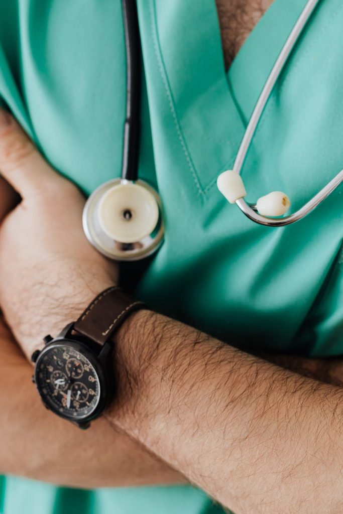 Doctor in scrubs with folded arms and stethoscope, symbolizing confidence in healthcare.